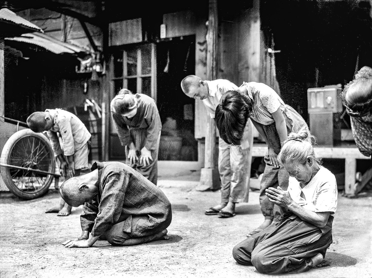 יפנים מאזינים להודעת הקיסר על הכניעה. יפן, 1945...