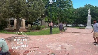 מפגינה עם דגל ישראל שרועה על הקרקע לאחר שנשרפה מהבקבוק תבערה...