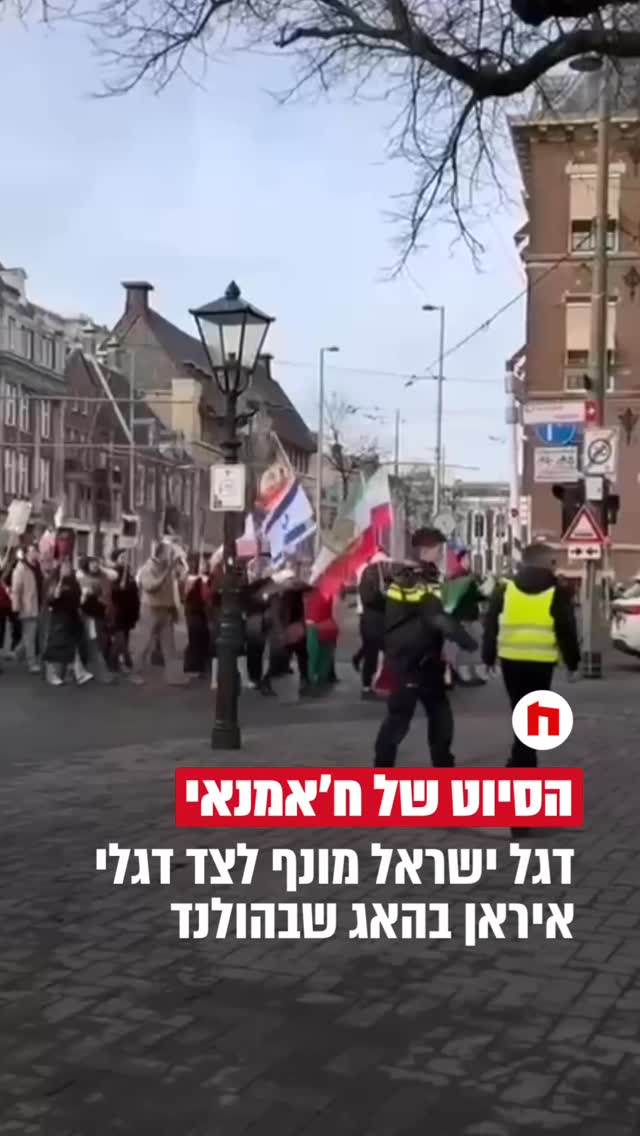 תיעוד יוצא דופן מהאג: מאות מפגינים נושאים דגלי איראן, עם סמל...