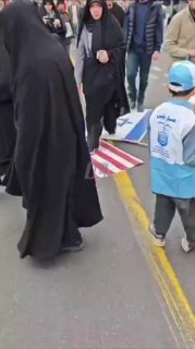 ההמון בטהרן דורכים על דגלי ארה"ב וישראל במהלך החגיגות היום....