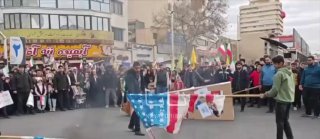 מציתים ודורכים: הריסת דגלי ארה"ב וישראל במהלך יום השנה למהפכה...