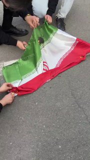 המפגינים שורפים את דגל טהרן...