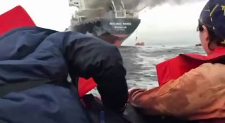 🚨 מלחים תאילנדים צופים בספינה שלהם בוערת במצרי הורמוז...